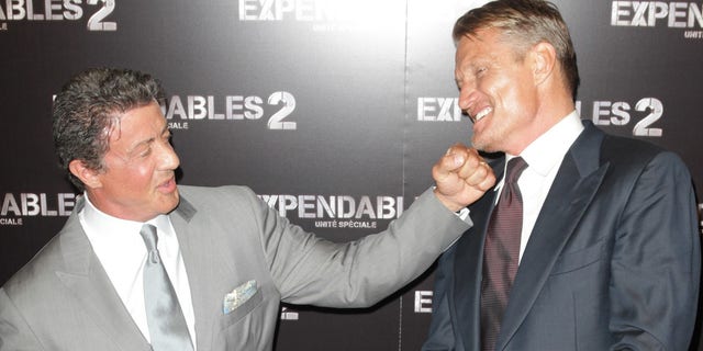 Sylvester Stallone pretends to punch Dolph Lundgren.