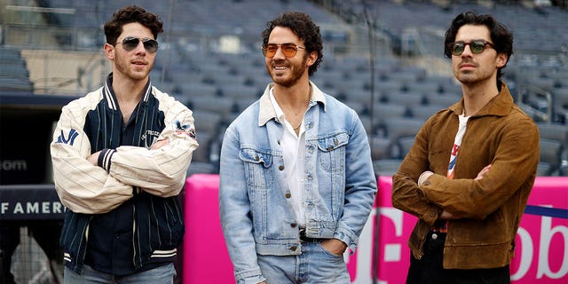 The Jonas Brothers standing in a stadium.