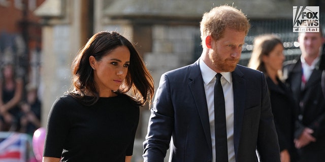 Downcast Meghan Markle in a black dress and Prince Harry in a black suit and black tie outside Windsor Castle after the Queen died