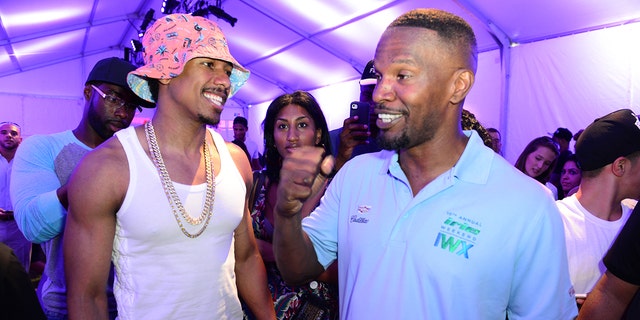 Nick Cannon laughing with Jamie Foxx