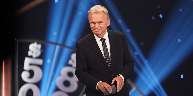 Pat Sajak leads contestants on Wheel of Fortune game show