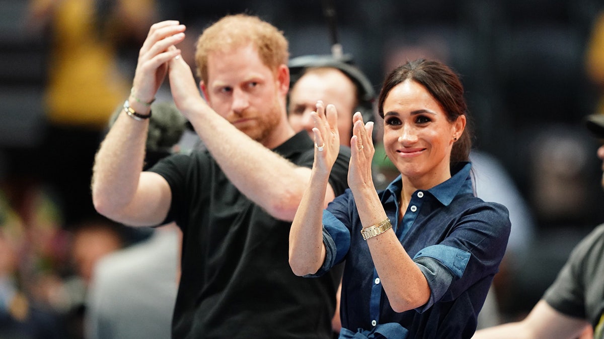 The Duke and Duchess of Sussex applauding in front of a crowd