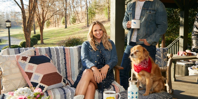 Miranda Lambert sitting on a porch with her husband Brendan McLoughlin and a dog.