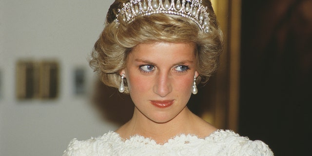 Princess Diana wearing the lover's knot tiara in a white dress looks off camera