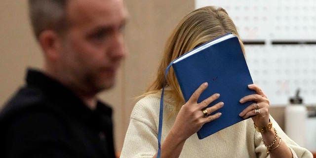 Gwyneth Paltrow shields her face with a blue notebook as she exits a courtroom Tuesday, March 21, 2023, in Park City, Utah. 