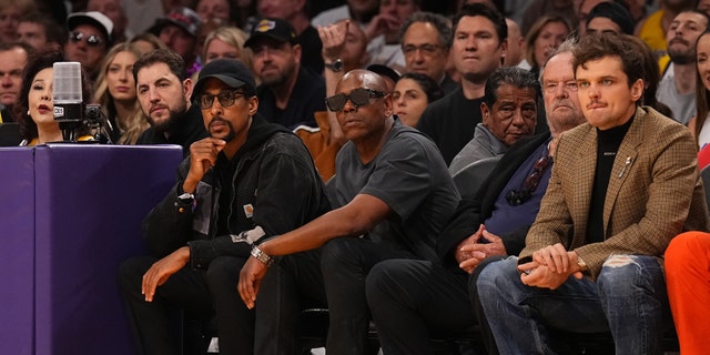 Dave Chappelle wears sunglasses next to Jack Nicholson and his son Ray Nicholson at Lakers game