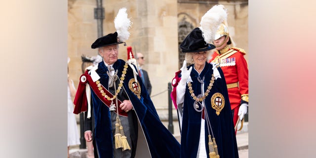 King Charles III and Queen Camilla in feathered hats during Order of the Garter procession.