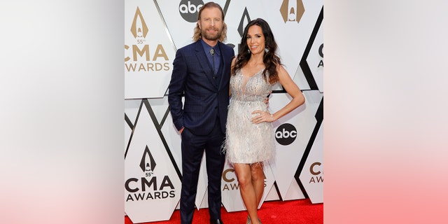 Dierks Bentley poses at the CMA Awards with his wife Cassidy in a white dress