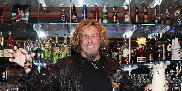 sammy hagar holding shot glass, drink and bottle of rum