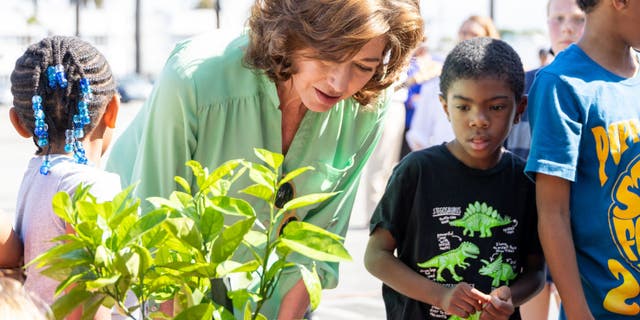 amy grant planting a tree with student