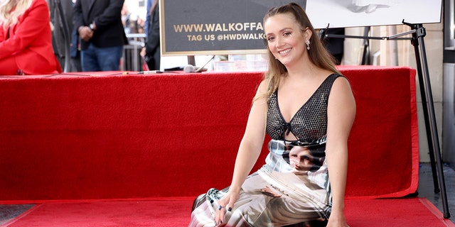 Billie Lourd sits on the red carpet and smiles with her late mother Carrie Fisher's new star on the Walk of Fame