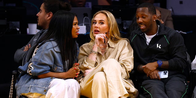 Nia Long faces Adele as they engage in conversation courtside at the Laker's game, while Rich Paul looks on