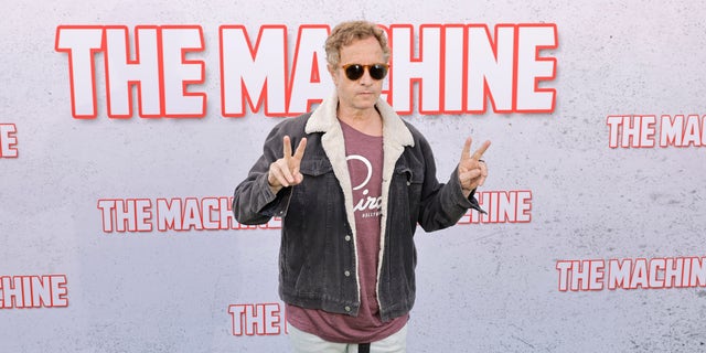 Pauly Shore gives the peace sign on the carpet at The Machine premiere