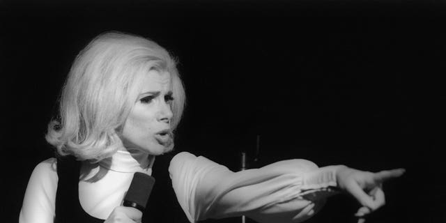Black and white photo of Joan Rivers on stage pointing