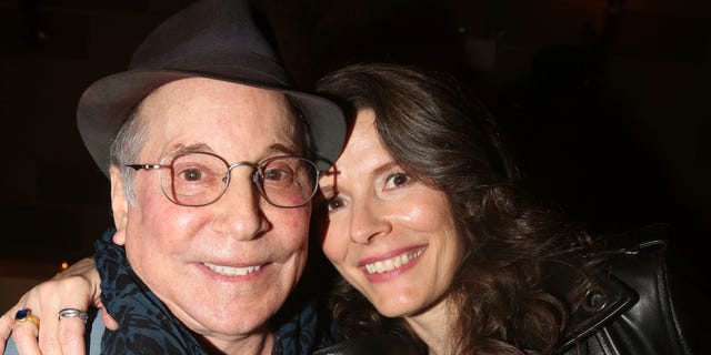 Paul Simon and wife Edie Brickell smiling in close up