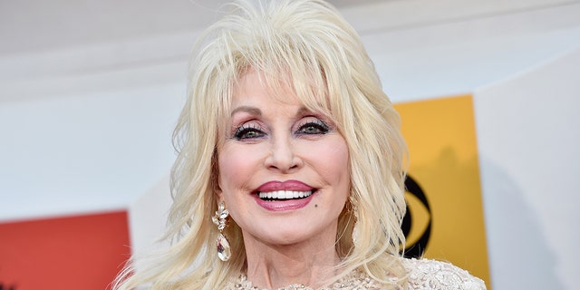 Dolly Parton smiles at a red carpet event.