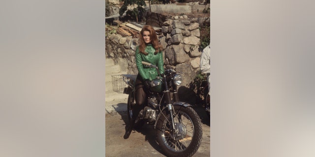 Ann-Margret in a short green dress on a motorcycle