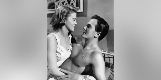 Ann-Margret in a white dress leaning against a shirtless Pat Boone