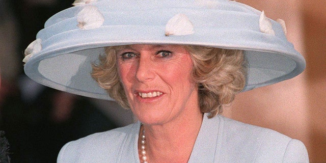 Camilla Parker Bowles in a blue dress with an oversized matching hat adorned with flowers