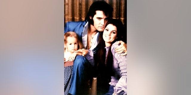 Lisa Marie Presley being embraced by her parents Elvis Presley and Priscilla