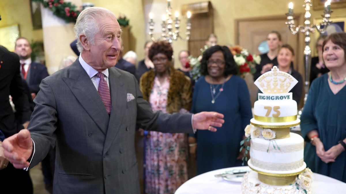 King Charles smiling in front of his birthday cake