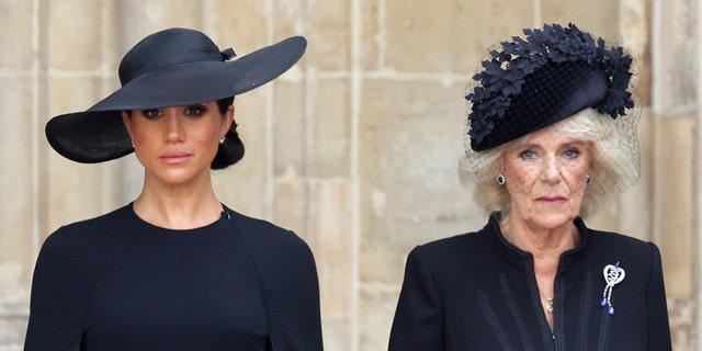 Meghan Markle and Queen Camilla, both wearing black, standing next to each other