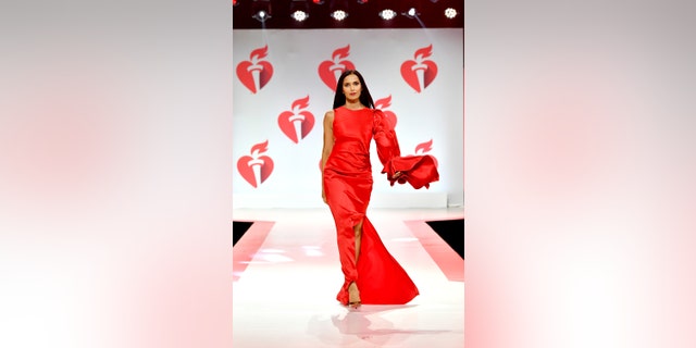 Padma Lakshmi wearing a bright red dress on the runway