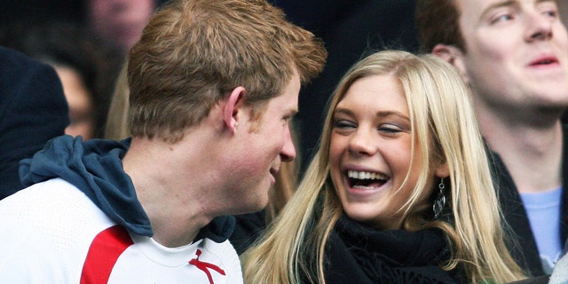 Prince Harry in a sports uniform laughing with Chelsy Davy wearing a scarf