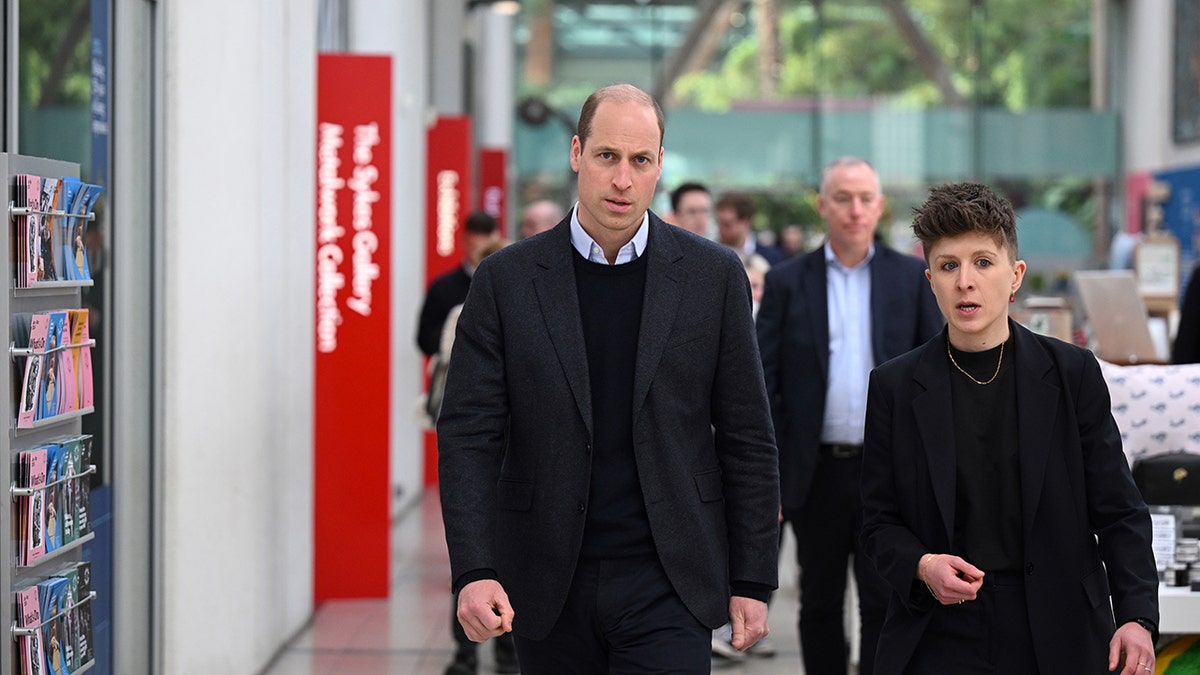 Prince William looking series as he walks in front of a group of people