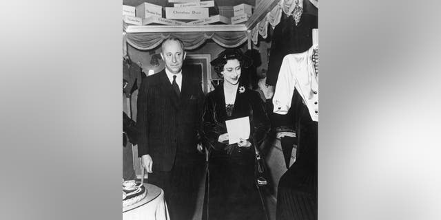 A black and white photo of Christian Dior and Princess Margaret standing next to each other