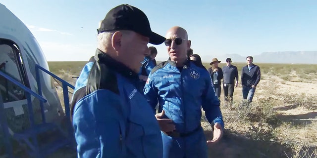 Jeff Bezos greets William Shatner in matching Blue Origin jumpsuits after space mission