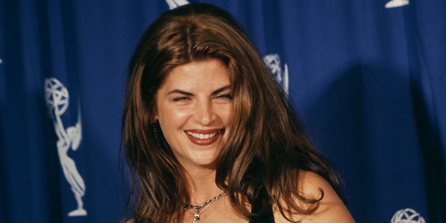 Kristie Alley hold her Emmy Award while wearing black dress