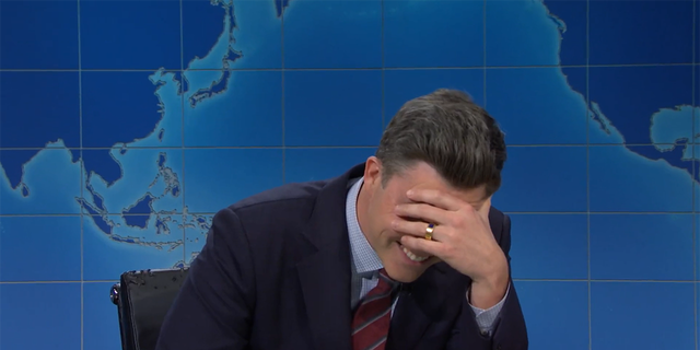 Colin Jost put his hand to his face, realizing Michael Che had pulled a prank on him.