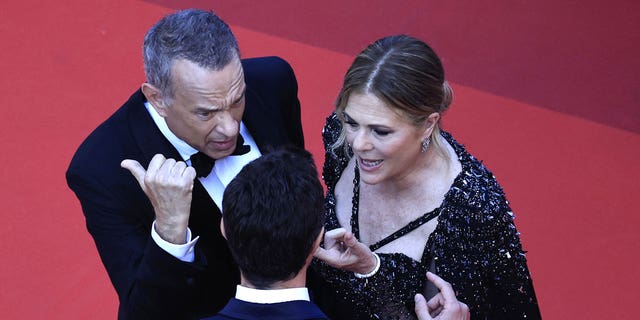 Tom Hanks talks to a staff member at Cannes