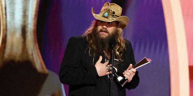 Chris Stapleton wears brown leather hat and black blazer to accept entertainer of the year award at acms