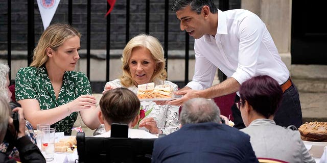 First Lady of the United States of America, Dr. Jill Biden, (C) and granddaughter Finnegan Biden (L) share cake with Prime Minister Rishi Sunak during a lunch at Downing Street