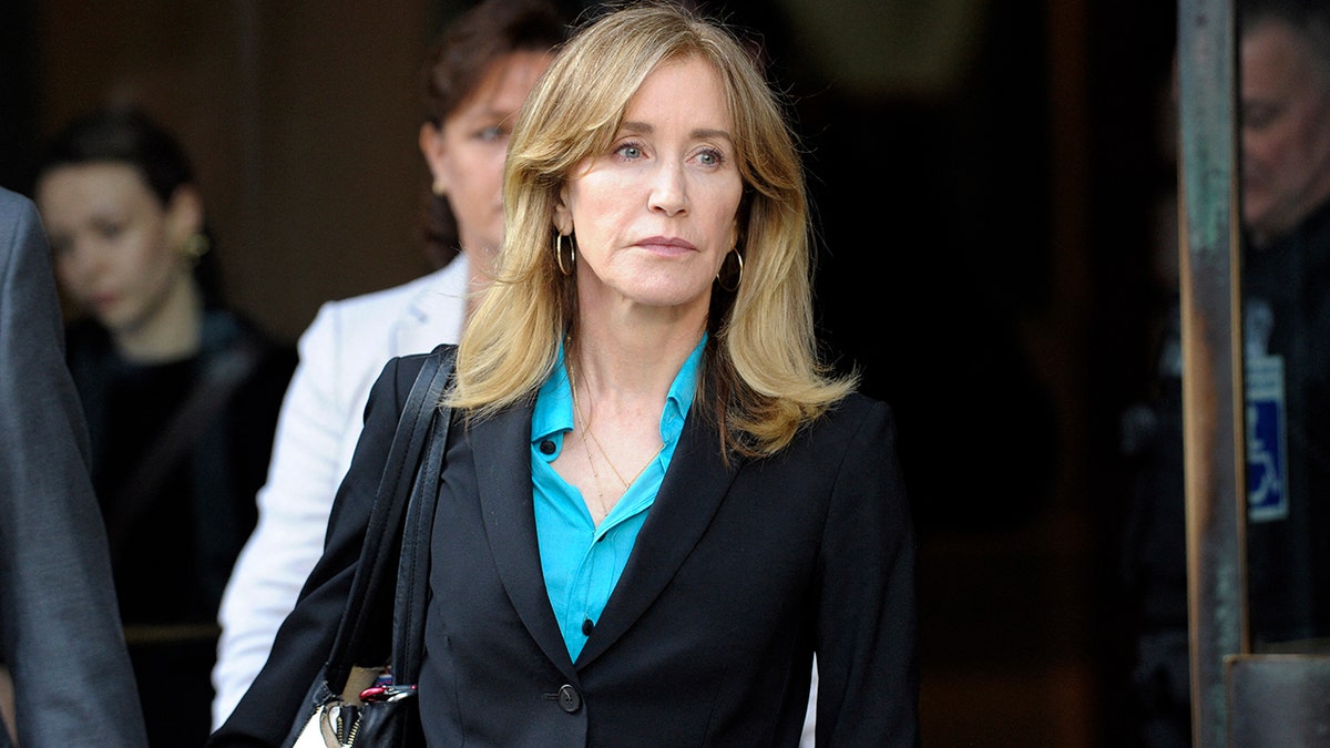 Felicity Huffman in front of the courthouse in a blue shirt and black blazer