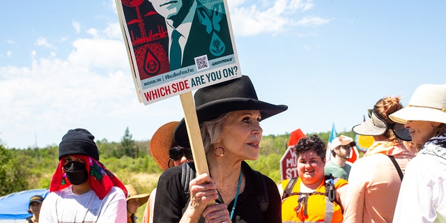 Jane Fonda holding protest sign