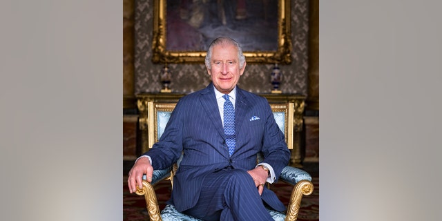 King Charles seated in Buckingham Palace