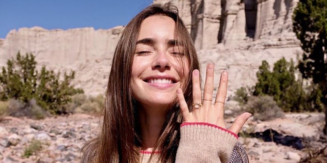 Lily Collins showing her engagement ring