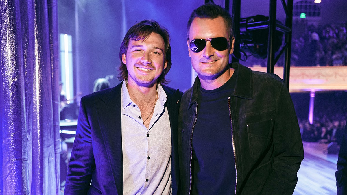 Country stars Morgan Wallen and Eric Church pose for photos after a concert.